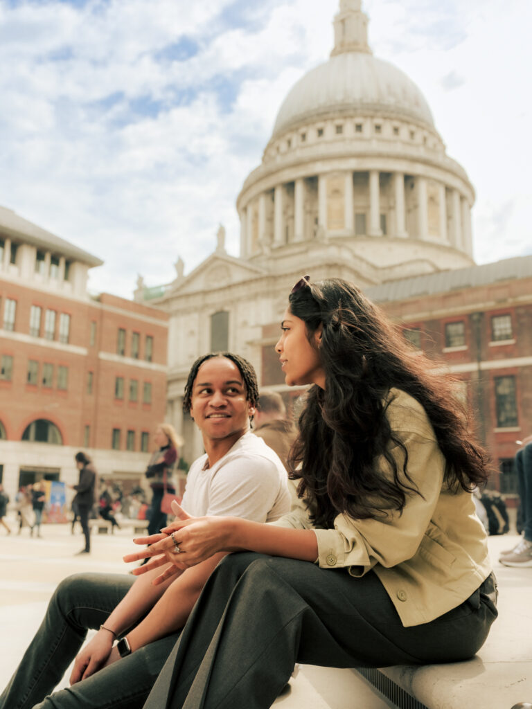 Things to do in the City of London - man and woman sat in front of St Paul's Cathedral chatting