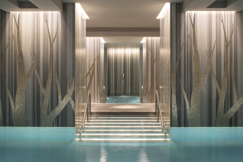 The Spa at Four Seasons London at Ten Trinity Square - spa interior - blue pool - silver trees painted on the walls