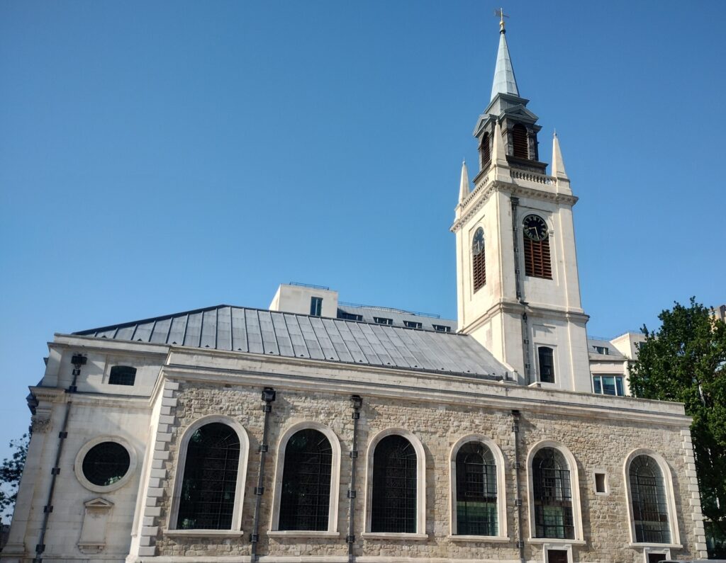 Exterior of St Lawrence Jewry - white stone church. Blue sky in the background.