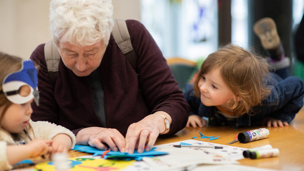 Two kids and their grand mother doing crafts