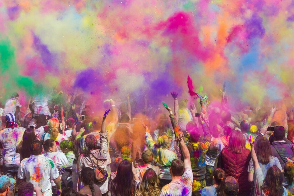 group of people throwing coloured powder in the air