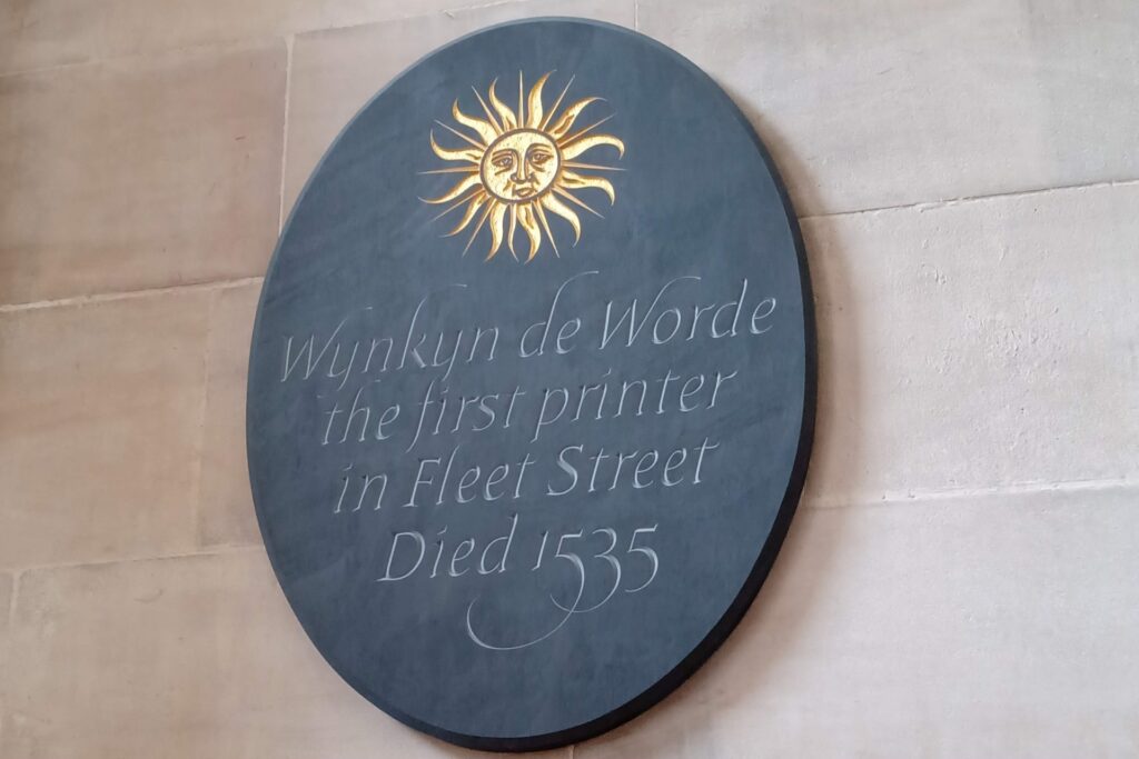 Plaque with an image of the sun and wording "Wynkyn de Worde the first printer in Fleet Street. Died 1535."