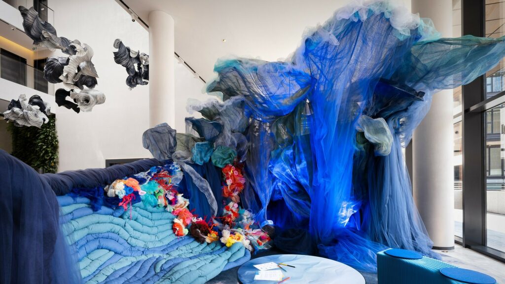 Indoor art installation that looks like a wave of water with various shades of blue