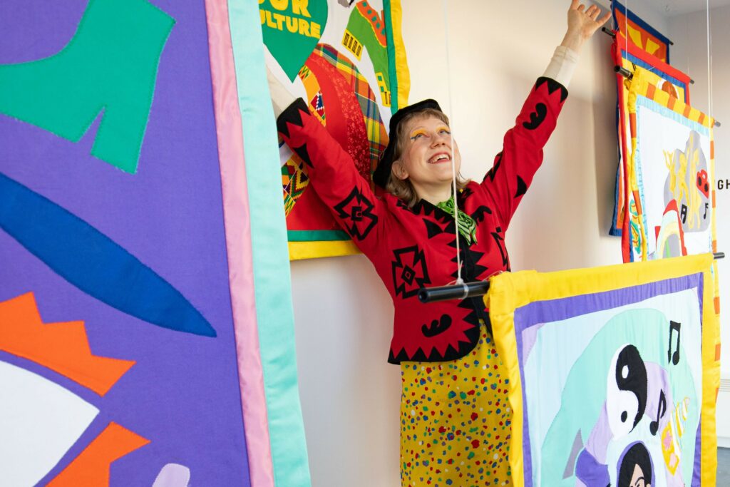 Person standing surrounded by colourful art.