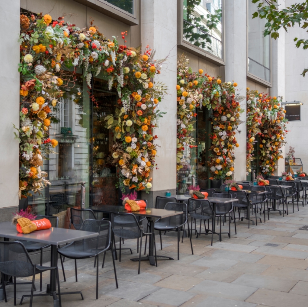 Floral decorations around the windows and doors, and outdoor tables.