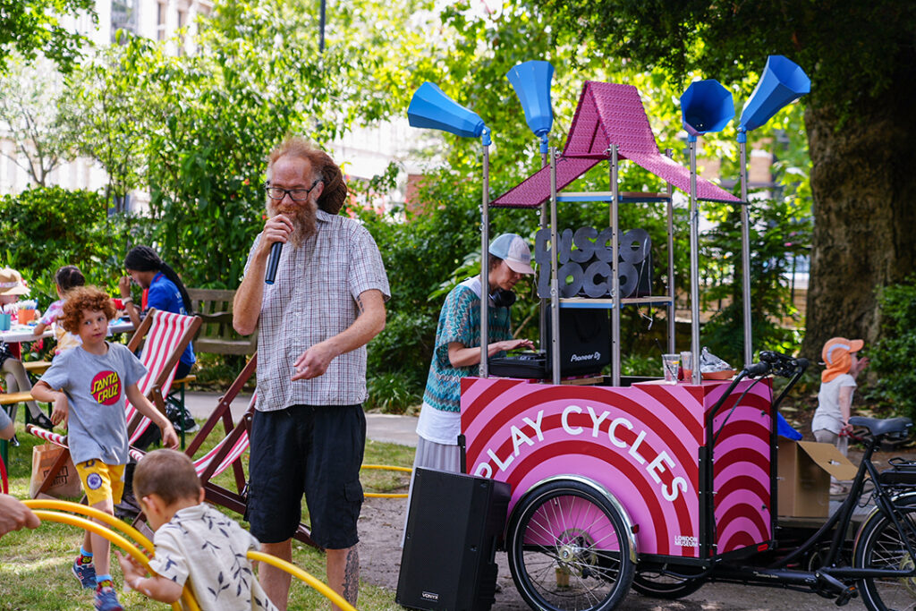 Man with a microphone animating children playing outdoors