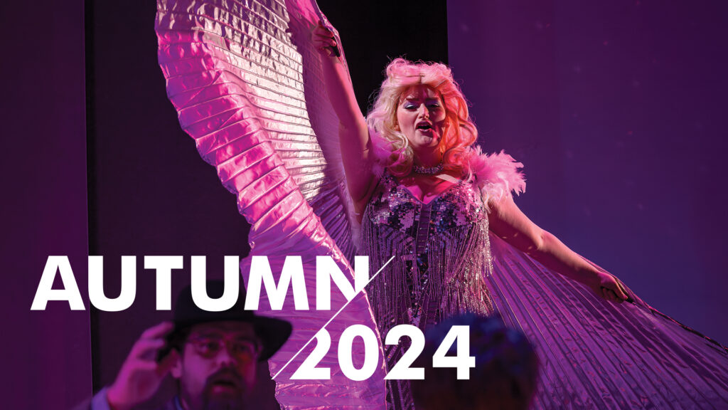 A figure is enveloped in pink and purple light, dramatically sweeping the wing of their costume upward.