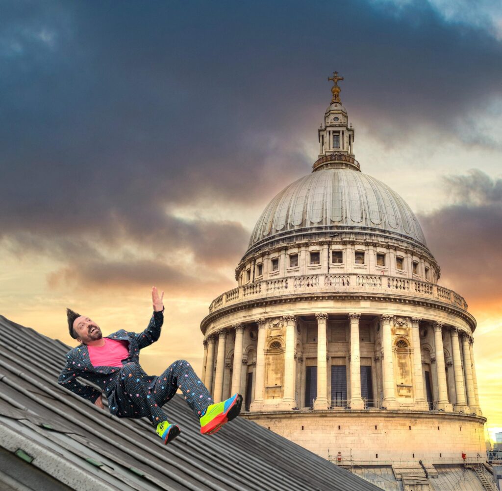 An individual is sliding down a rooftop slope with the backdrop of St Paul's Cathedral.