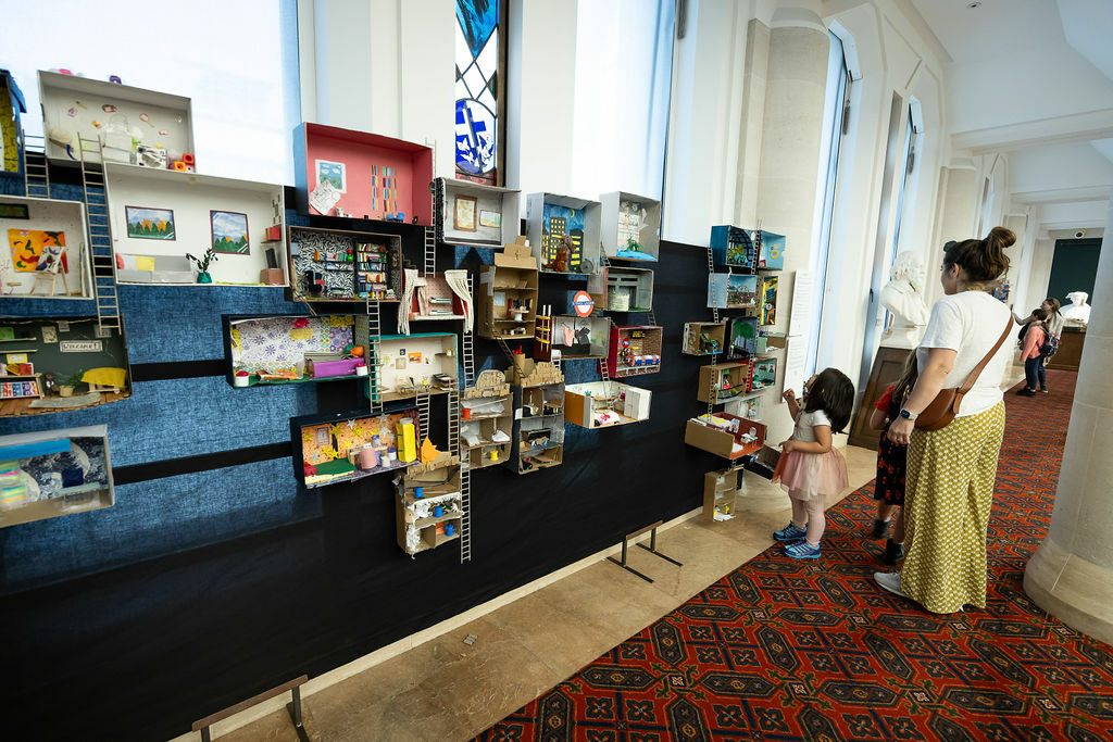 Doll house installation made of shoeboxes connected by ladders